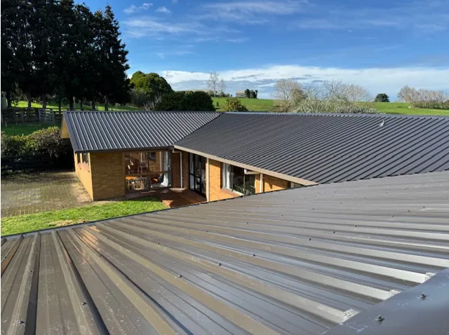 After: the same home with a new dark long-run roof