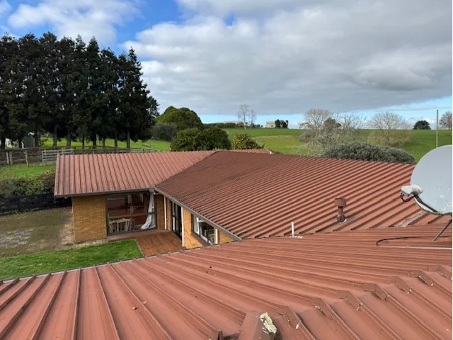 Before: old red iron roof on a brick home