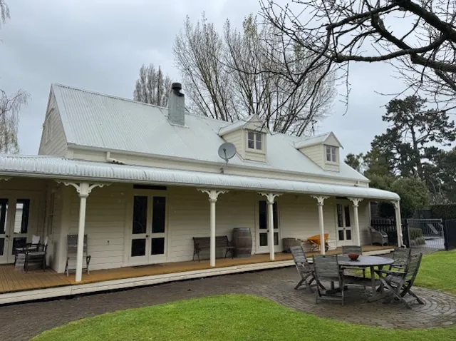 Before: tired painted iron roof on a villa with a verandah